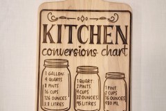 Cutting board with kitchen conversions chart engraved on one side